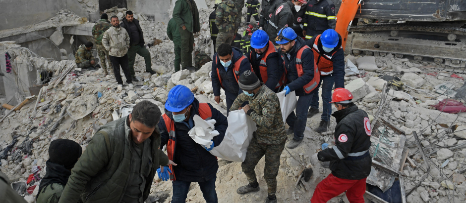 Rescuers carry the body of a victim recovered under the rubble of a collapsed building in Syria's northern city of Aleppo on February 8, 2023, two days after a deadly quake struck Syria and Turkey. (Photo by AFP)