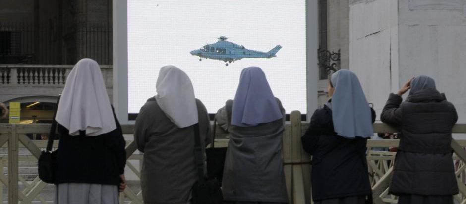 Varias religiosas observan el helicóptero de Benedicto XVI el día de su renuncia
