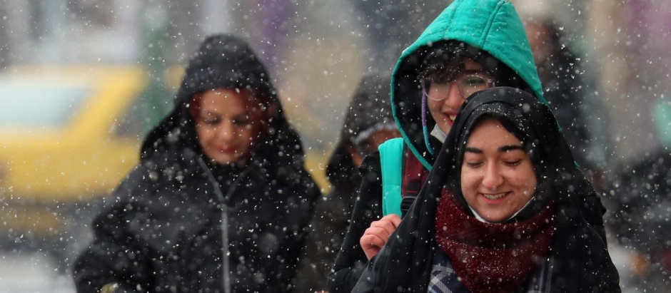 Los iraníes se protegen de la nevada en Teherán, Irán
