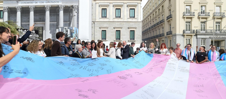 Varias personas sostienen la bandera trans que la Federación Estatal de Lesbianas, Gais, Trans, Bisexuales, Intersexuales y más (Flegtbi+), Chrysallis y Fundación Triángulo han llevado al Congreso de los Diputados, a 27 de octubre de 2022, en Madrid (España). El fin de llevar la bandera trans al Congreso es visibilizar su protesta ante los rechazos que sufre la tramitación de la conocida como ‘ley trans’ y exigir que el texto ‘’no sufra recortes’’. Los tres colectivos aprovechan su acto de protesta ante la Cámara Baja para reclamar a los representantes de los distintos grupos parlamentarios que firmen la bandera como muestra de su compromiso de “acelerar los trámites parlamentarios”. La acción tiene lugar en el marco del ‘Octubre trans’.
27 OCTUBRE 2022;LGTBI;TRANS;LEY;LEY TRANS;
Gustavo Valiente / Europa Press
(Foto de ARCHIVO)
27/10/2022