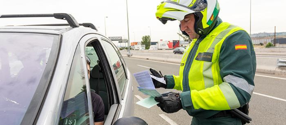 Un agente de la Guardia Civil poniendo una multa a un conductor