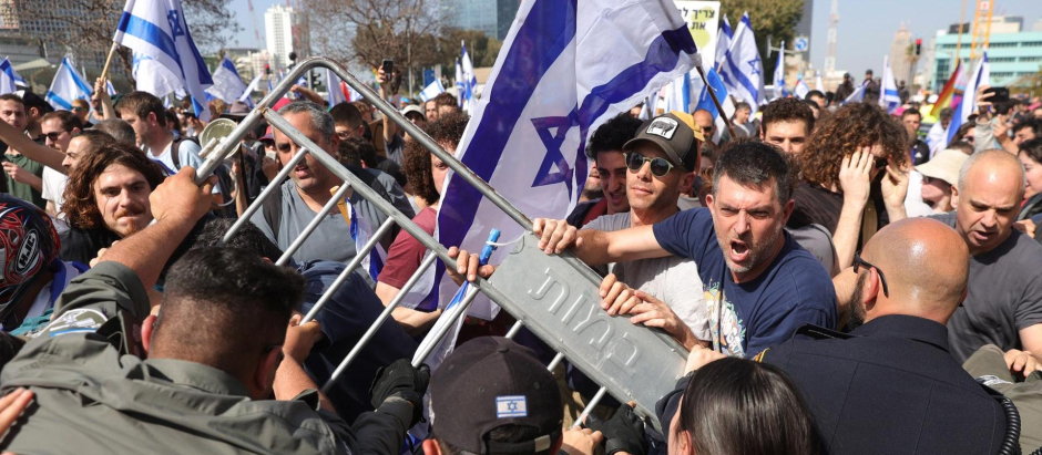 La policía retiene a los manifestantes que bloquean la carretera Ayalon en el centro de la ciudad durante una protesta antigubernamental en Tel Aviv, Israel