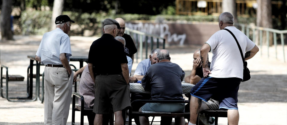 Varios pensionistas juegan al dominó en un parque de Madrid.