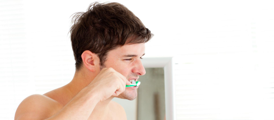 Un hombre se cepilla los dientes