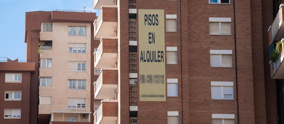 Cartel de alquiler de viviendas en la fachada de un edificio en Barcelona.