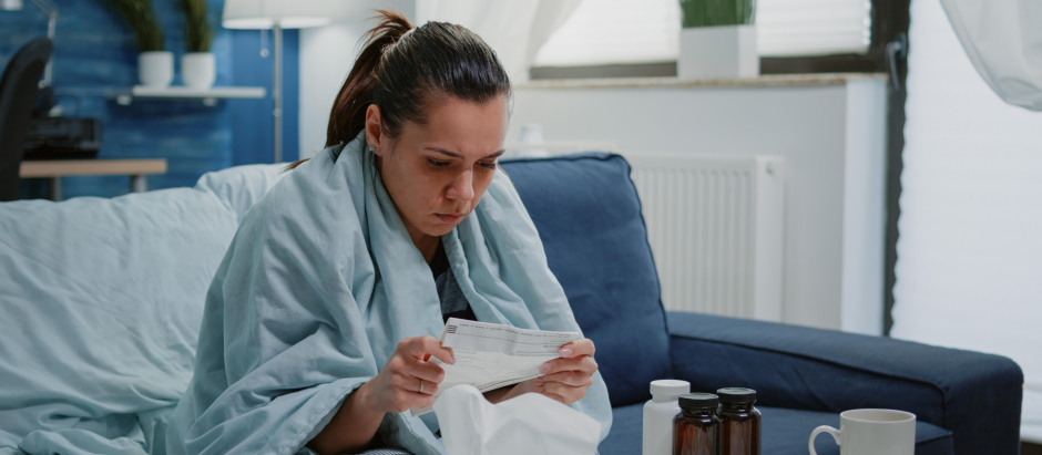 Mujer con gripe leyendo el prospecto
