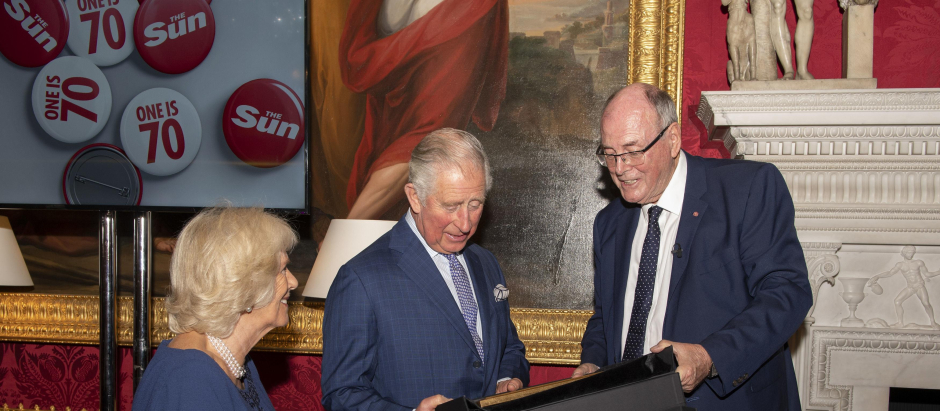 Prince Charles of Wales and the Duchess of Cornwall are presented with a book from photographer Arthur Edwards during a tea party held at Spencer House in London to celebrate 70 inspirational people marking their 70th birthday this year. *** Local Caption *** .