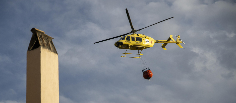 Un helicóptero con una cuba de agua para apagar el incendio forestal originado en Villanueva de Viver