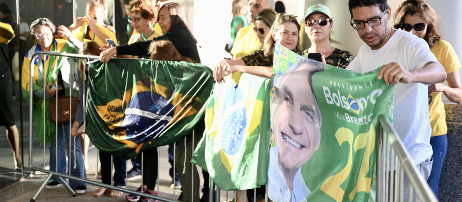 Supporters of former Brazilian president Jair Bolsonaro wait for his arrival at the Liberal Party headquarters in Brasilia on March 30, 2023. - Disconsolate over his "unjust" defeat in Brazil's divisive 2022 elections, Bolsonaro was uncharacteristically quiet when he slipped out of Brazil in the twilight of his presidential term for a self-imposed exile in Florida. (Photo by Evaristo Juliano DE SA and EVARISTO SA / AFP)