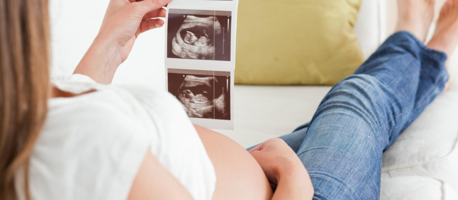 Una mujer embarazada mira una ecografía