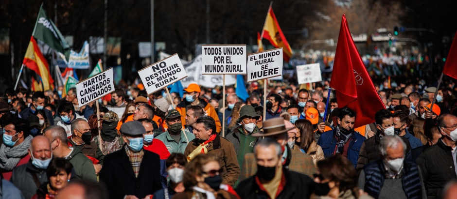 Varios manifestantes con pancartas en la movilización en defensa del campo y del mundo rural