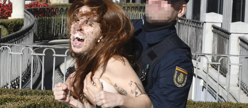 MADRID, 20/11/2022.- Una activista de Femen es interceptada por la policía mientras irrumpe en la concentración Movimiento Católico Español, convocada este domingo en Madrid en protesta por la Ley de Memoria Democrática. EFE/ Víctor Lerena