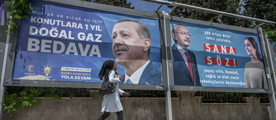 Una mujer siria pasa junto a vallas publicitarias sobre la campaña electoral en Turquía