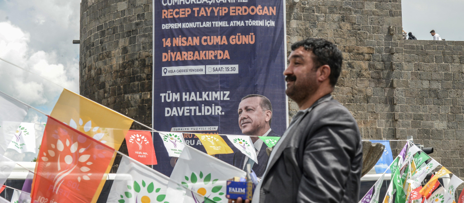 Un hombre pasa junto a una pancarta con un retrato del presidente turco, Recep Tayyip Erdogan