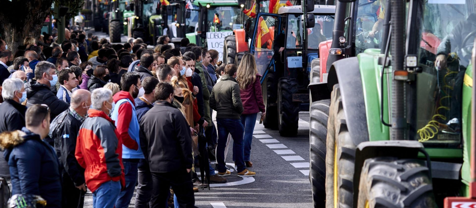 Manifestantes y tractores, con pancartas y banderas de España, en una marcha en marzo de 2022