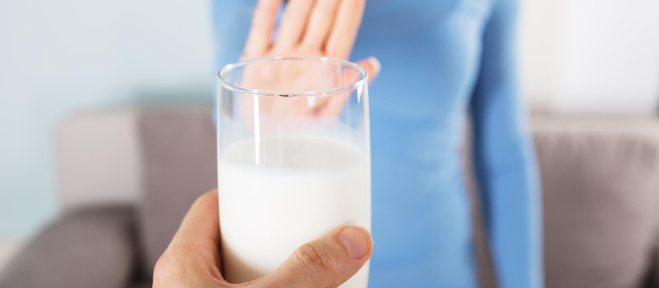 Close-up Of A Woman Rejecting Glass Of Milk At Home