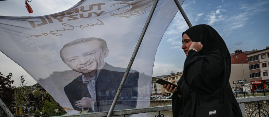 Una mujer pasa junto a una bandera del presidente turco Recep Tayyip Erdogan