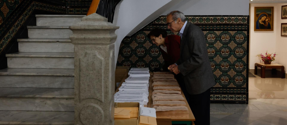 Dos personas escogen sus papeletas en el colegio Nuestra Señora del Buen Consejo de Madrid.