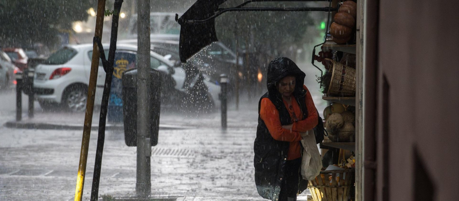 Una mujer con paraguas bajo la lluvia en Madrid
