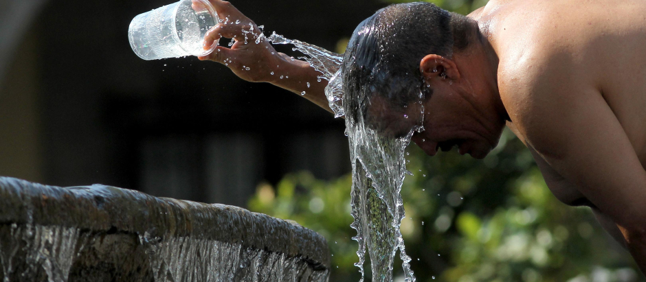 Un hombre se refresca con agua de una fuente de agua durante uno de los días más calurosos de la tercera ola de calor en Guadalajara, estado de Jalisco, México