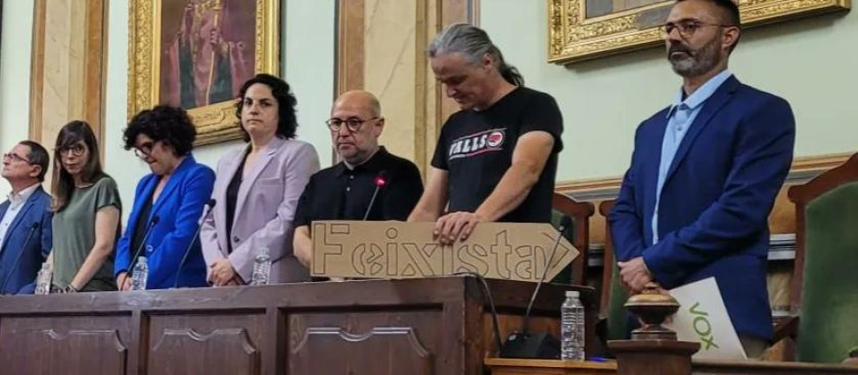 El concejal de la CUP Pere Vidal señala al concejal de Vox con un cartel donde se lee «fascista»