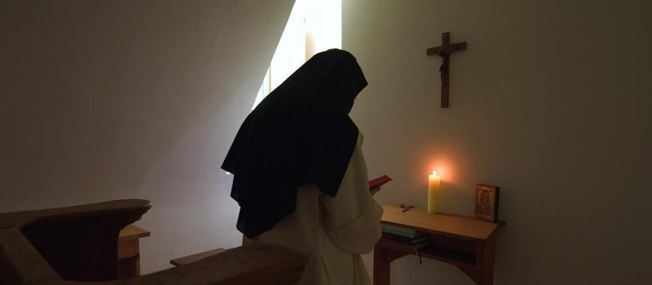 Una monja cartuja orando en su eremitorio