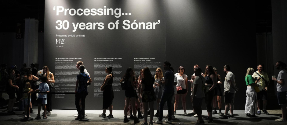Varias personas hacen cola para visitar la instalación de gran formato "Processing... 30 years of Sónar"