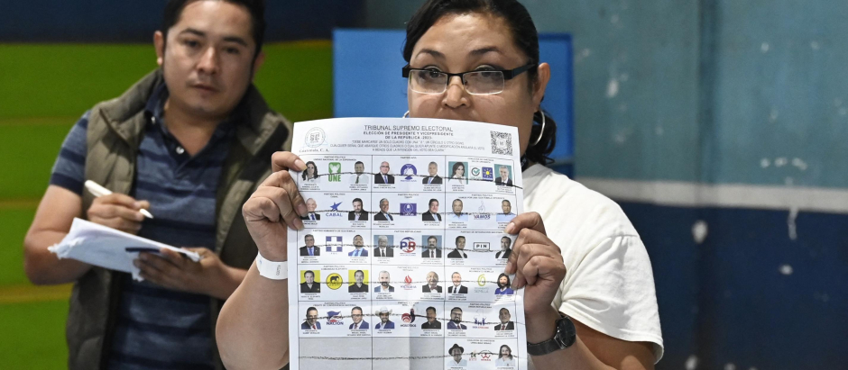 Una funcionara de mesa muestra una boleta con un voto nulo