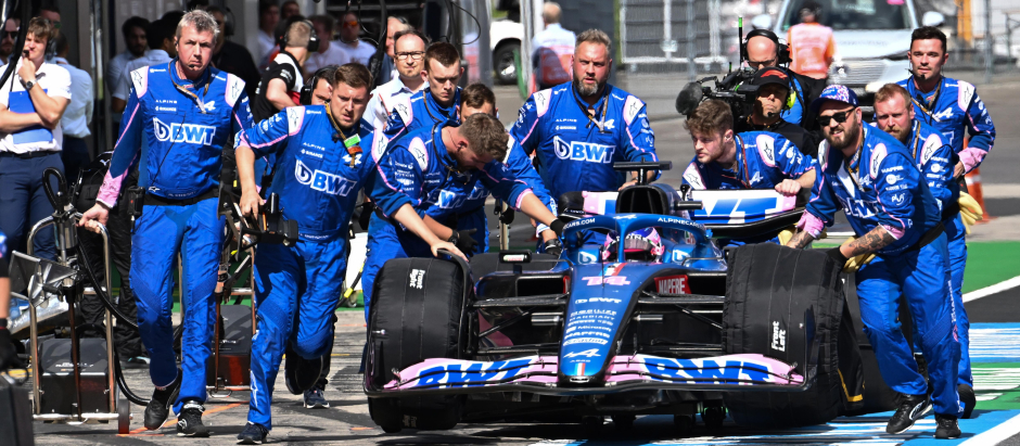 Los mecánicos de Alpine llevan el coche de Alonso por el pit lane en el Gran Premio de Austria 2022