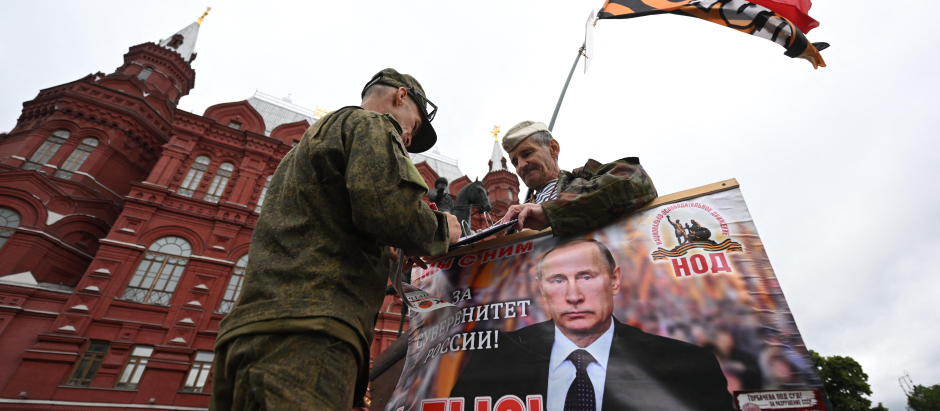 Partidarios del presidente Vladimir Putin portan carteles en la Plaza Roja de Moscú