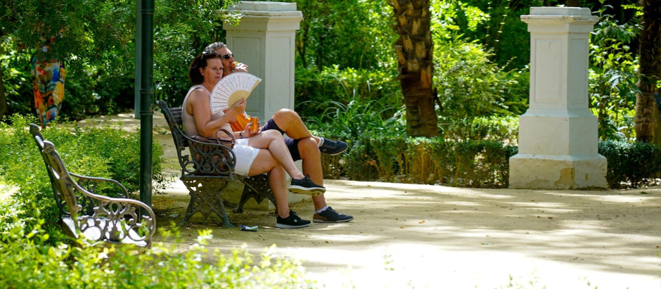 Una pareja bebe agua en  el Parque de María Luisa en la primera ola de calor