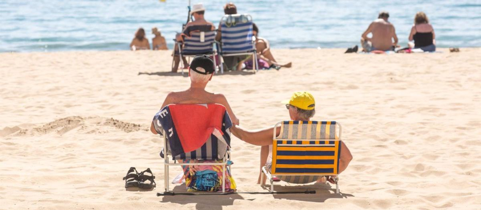 Numerosas personas se bañan y toman el sol en la playa de Poniente, Benidorm, Alicante