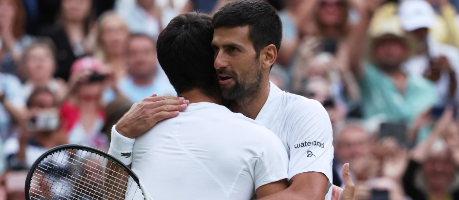 Carlos Alcaraz y Novak Djokovic se abrazan después de la final de Wimbledon