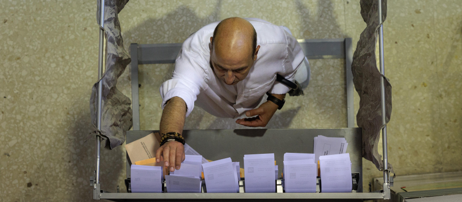 Un hombre escogiendo su papeleta para votar