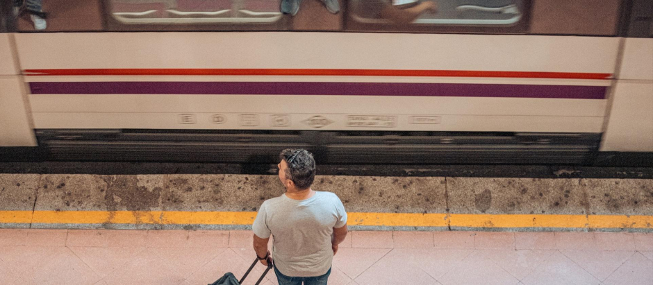Un hombre espera en el andén de un tren