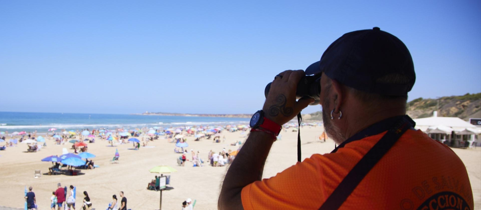 Un vigilante de la playa observa a los bañistas desde su torre en la playa de la Fontanilla en Conil de la Frontera