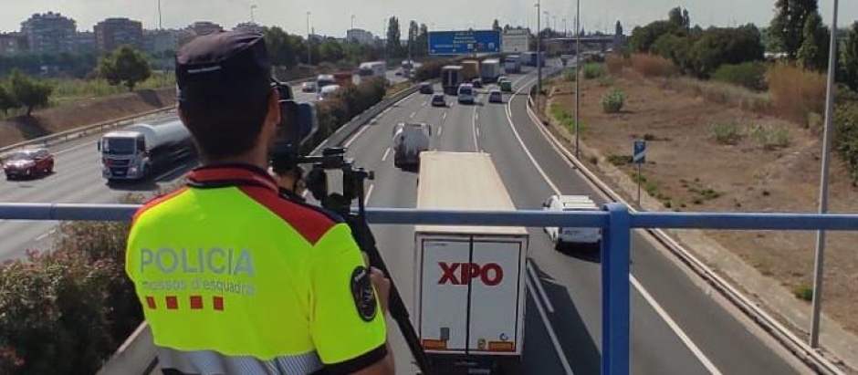 A pillar, un Mosso mide los vehículos que pasan bajo un puente con un radar móvil