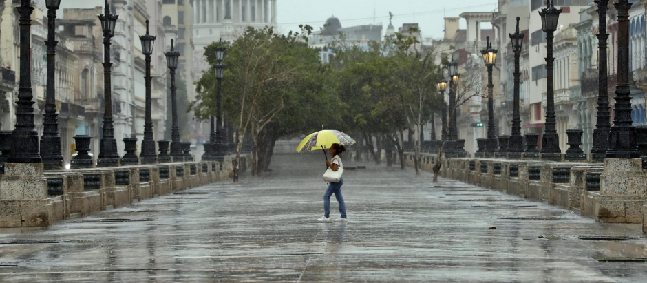 Una mujer se protege de la lluvia, en La Habana (Cuba) por el paso de la tormenta tropical Idalia