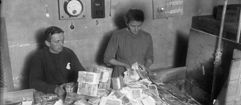 Funcionarios alemanes recolectando el papel moneda devaluado, enero de 1924