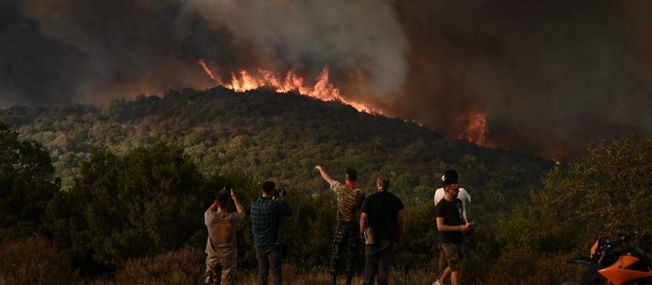 La gente observa el incendio forestal que arrasa un bosque en Sikorahi, cerca de Alexandroupoli, al norte de Grecia