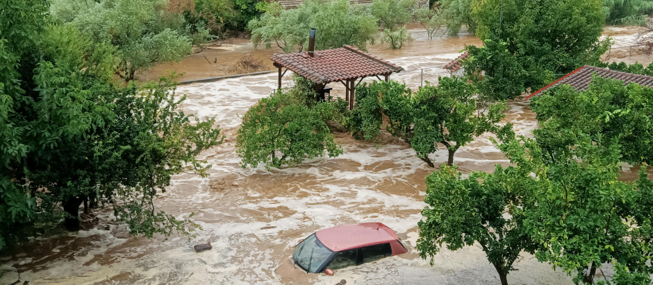Un automóvil y casas en una zona inundada en Volos