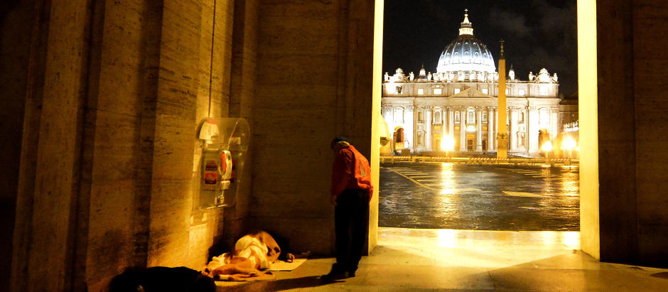 Un voluntario de la asociación City angels habla con una persona sintecho en el Vaticano