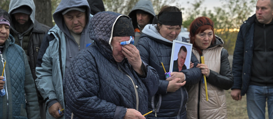 Familiares y amigos lloran ante un ataúd en la aldea de Groza, Ucrania