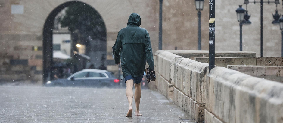 Una persona camina bajo la lluvia en Valencia