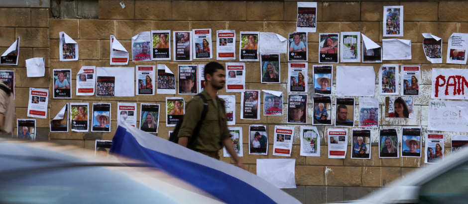 Un soldado israelí pasa junto a imágenes de rehenes israelíes secuestrados por Hamás