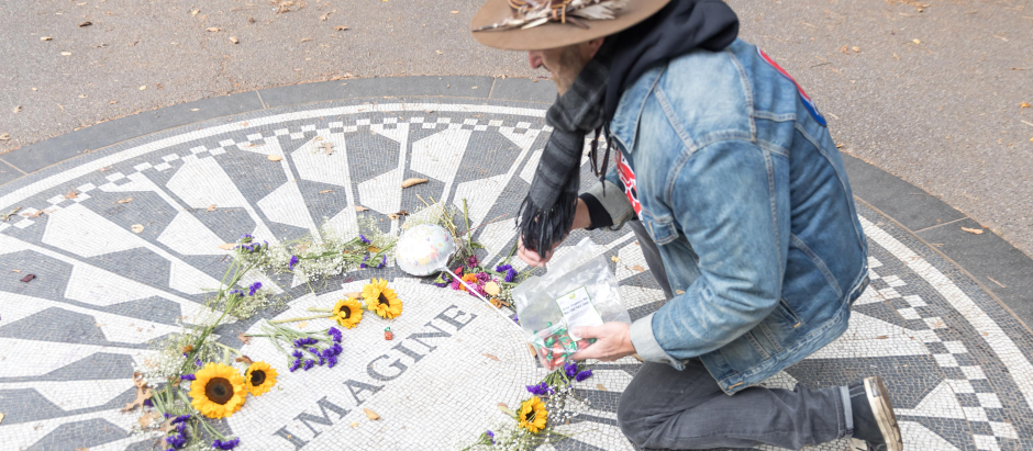 Un fan que le está rindiendo homenaje a John Lennon en la placa del Central Park en su honor