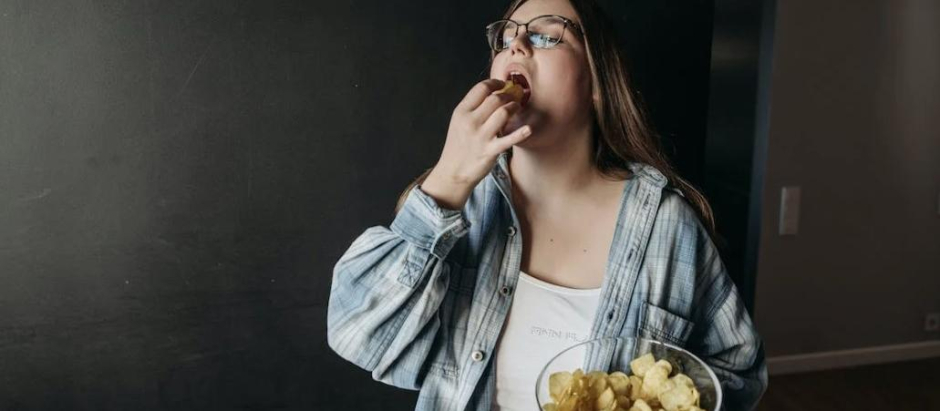 Una chica come patatas fritas, en una imagen de archivo