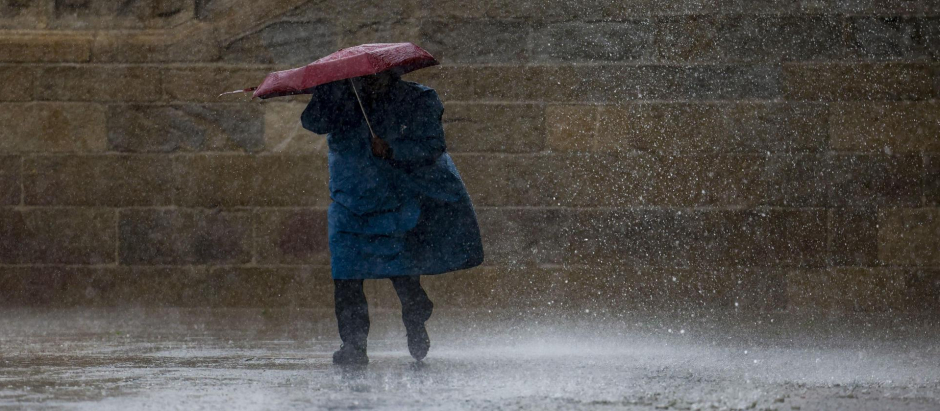 Un peregrino bajo la lluvia este sábado en la plaza del Obradoiro en Santiago de Compostela