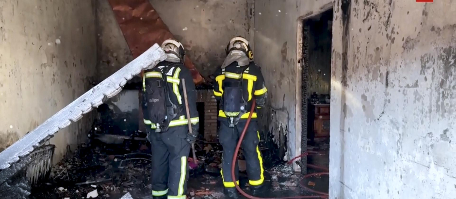 Bomberos de la Comunidad de Madrid apagando el fuego de la vivienda afectada