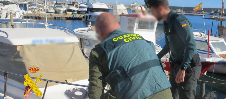 Agentes de la Guardia Civil con una de las embarcaciones ilegales decomisadas